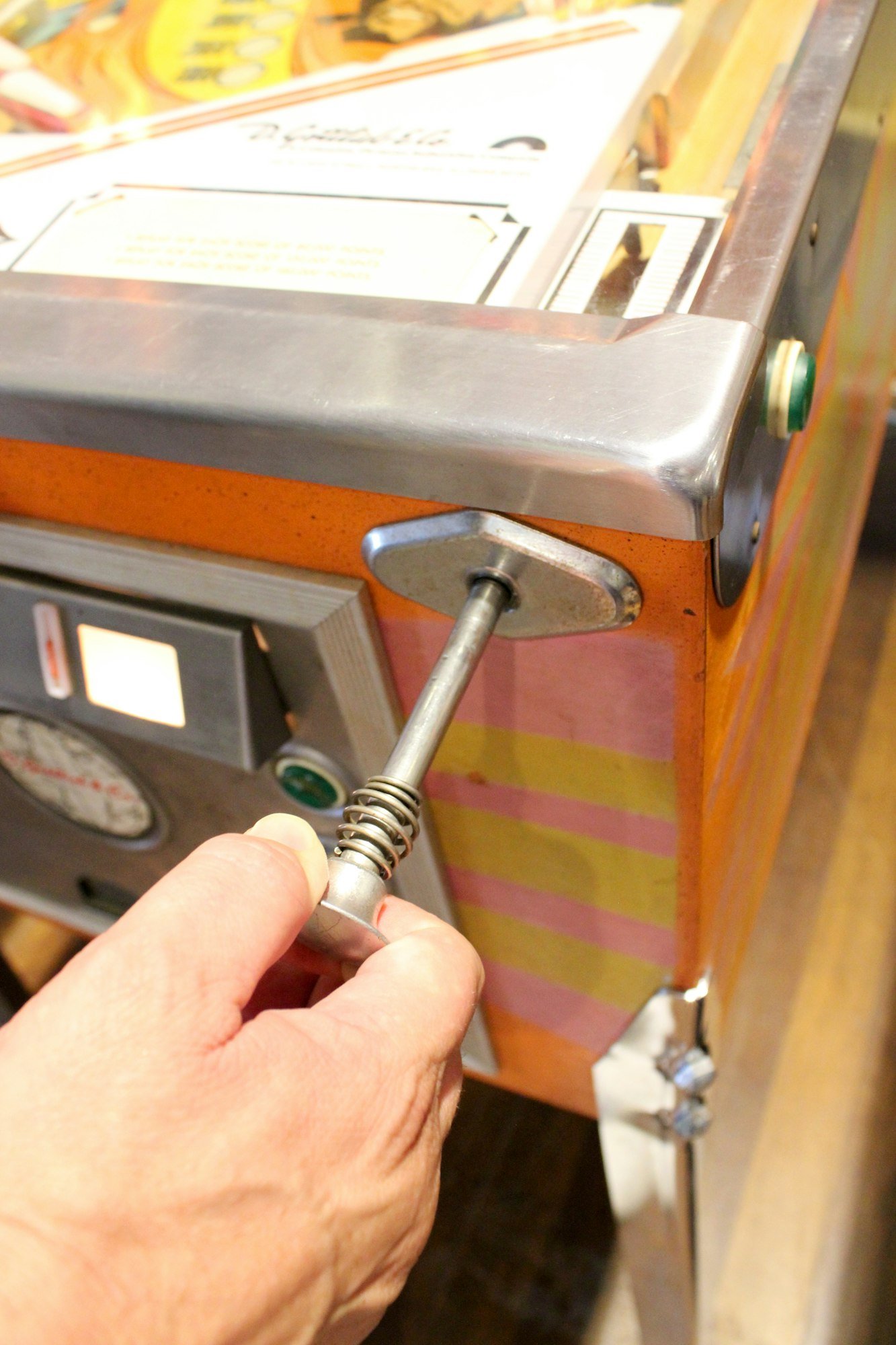 Teenagers playing an old fashioned, retro, vintage game of pinball