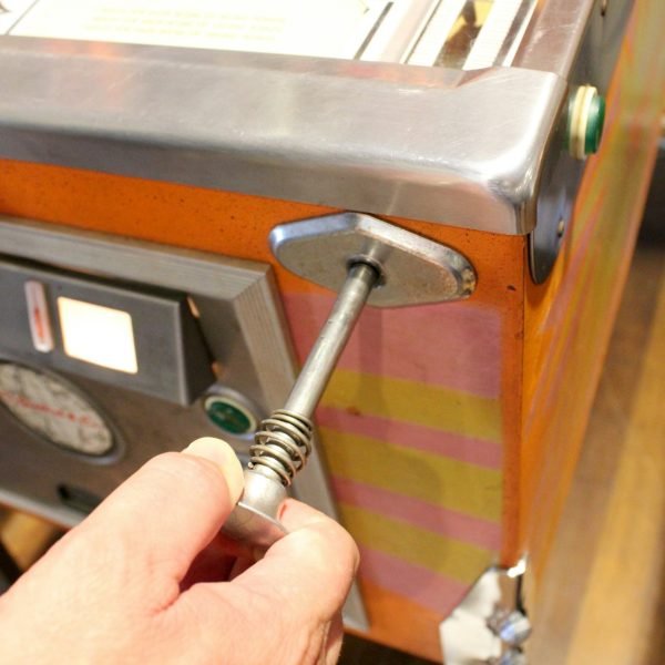 Teenagers playing an old fashioned, retro, vintage game of pinball